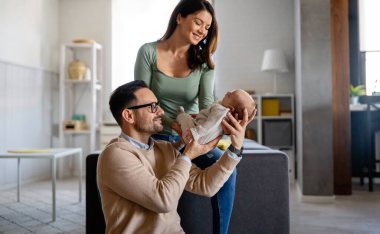 Aile sevgisi bebek konsepti. Genç ebeveynler yeni doğan çocukla mutlu anlar geçirirler.