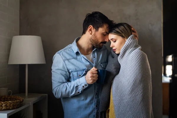 悲伤的年轻夫妇裹在毯子里 喝着热茶 试图取暖 冻结患感冒或流感发烧或中央暖气问题的男女 — 图库照片
