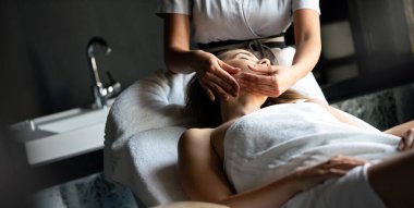 Kaplıca salonunda masaj yaptıran genç bir kadın