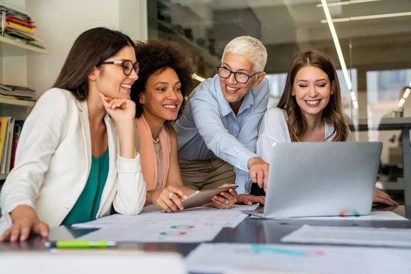 Collaboration and analysis by business people working in office. Successful business women together in corporate office.