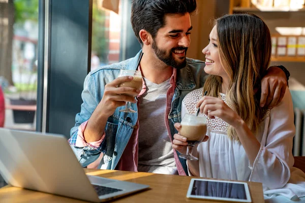 幸せな若いカップルは カフェで笑顔で座って ノートパソコンの画面を見て 喜びと時間を過ごし コーヒーを飲む — ストック写真