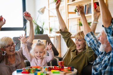 Neşeli, çoklu kuşak bir aile evde birlikte vakit geçirirken eğleniyor. İnsanların mutluluk kavramı.