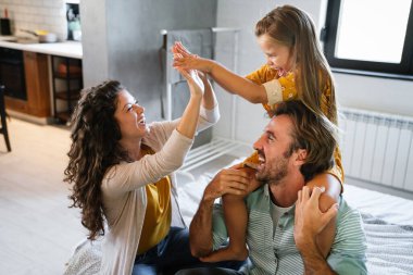 Mutlu genç aile evde eğleniyor. Ebeveynler çocuk sevgisi kavramı.