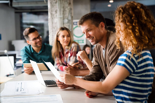 Smiling diverse colleagues gather in boardroom brainstorm discuss financial statistics together, happy multiracial coworkers have fun cooperating working together at office meeting, teamwork concept