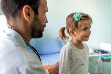 Pediyatrist doktor klinikte küçük bir kızı muayene ediyor. Sağlık hizmeti, çocuk konsepti.