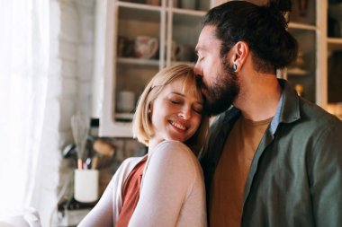 Çok ırklı çift evde gülümseyerek birlikte güzel vakit geçirir. İnsanların mutluluk kavramı.