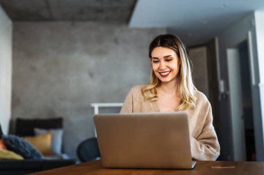 Merkez ofis. Laptop kullanan gülümseyen genç bir kadın. Çalışma, serbest çalışma, sosyal medya, teknoloji kavramı.