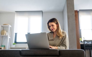 Genç başarılı kadın serbest çalışan dizüstü bilgisayarında yeni bir proje üzerinde çalışıyor. Teknoloji işi iş adamları kavramı.