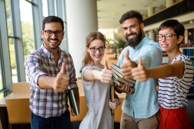 Bir kolej kütüphanesinde birlikte çalışıp çalışan bir grup başarılı öğrenci. Eğitim insanları öğrenme kavramı.