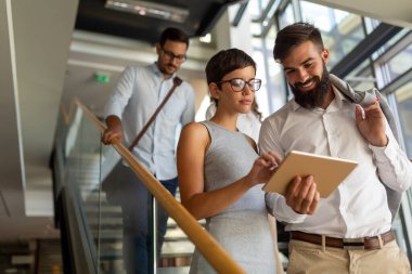 Bir grup genç iş adamı ofiste birlikte çalışıyor ve iletişim kuruyorlar.