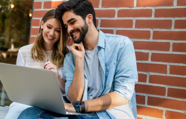 Dijital cihazlarla çalışan genç ve mutlu başarılı insanlar. İş eğitimi teknolojisi cep telefonu kavramı