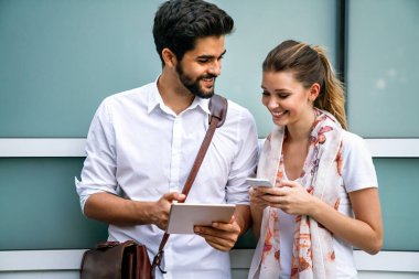 Happy busy business people outdoors with digital devices. Business technology smartphone, digital tablet concept