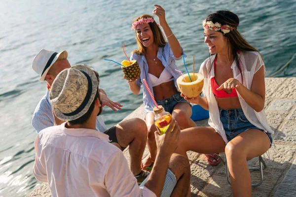 Group of friends having Hawaiian party on summer vacation. People fun travel sea concept.