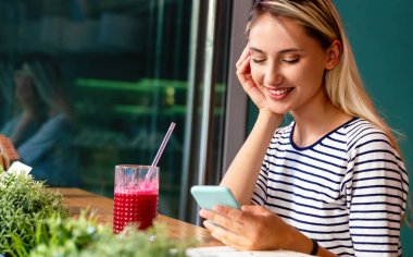Akıllı telefon kullanan mutlu genç bir kadının portresi. İnsanlar cep telefonu bağlantısı çalışma kavramı