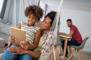 Mutlu Afrikalı kız elinde dijital tabletle evde para kazanıyor. Gülümseyen çocuk aygıt mesafesi öğrenme ile sosyal medya videoları sanal ders sınıfını online olarak izliyor