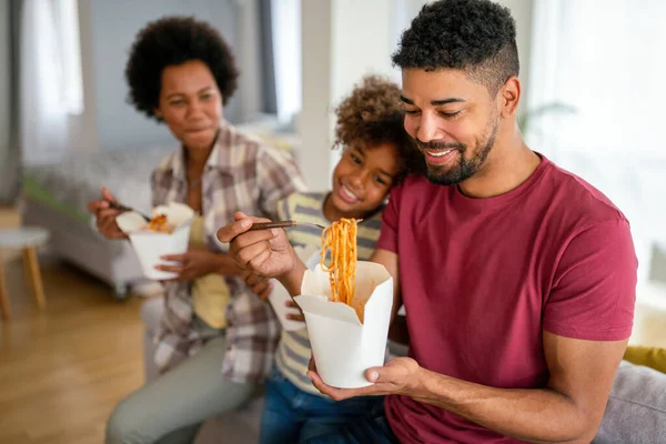 Family home delivary takeaway food concept. Happy african american family eating at living room and enjoying time together.