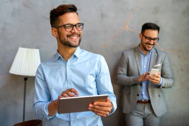 Mutlu halefin portresi genç iş adamı, lider, yönetici dijital tablet kullanarak çalışıyor. İş teknolojisi kavramı.