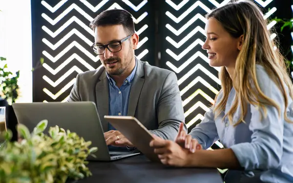 İş projesi ekibi şirket ofisindeki toplantı odasında birlikte çalışıyor.