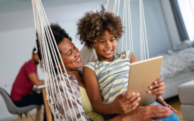 Çocuklu mutlu Afro-Amerikan anne portresi eğitim, eğlence ve oyun için dijital tablet kullanıyor. Teknoloji insanları kavramı