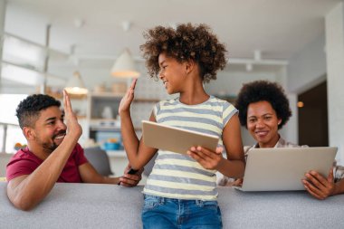 Teknolojik cihazlara takıntılı mutlu Afro-Amerikan ailesi dijital tablet, bilgisayar, akıllı telefonlar kullanıyor. İnternet sitesi, iş, eğitim ve internet üzerinden okuma, film veya bir mim için teknoloji