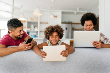 Teknolojik cihazlara takıntılı mutlu Afro-Amerikan ailesi dijital tablet, bilgisayar, akıllı telefonlar kullanıyor. İnternet sitesi, iş, eğitim ve internet üzerinden okuma, film veya bir mim için teknoloji