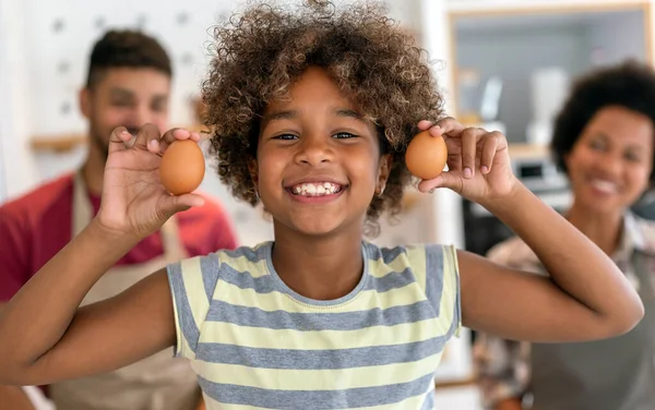 stock image Overjoyed young african american family with kid have fun cooking at home together, happy smiling parents enjoy weekend play with child in kitchen