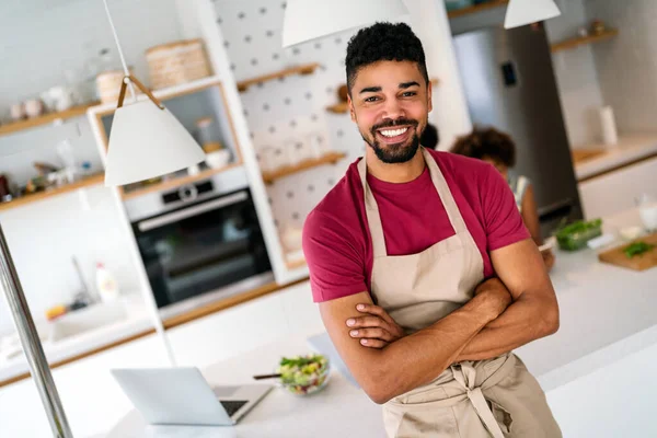 Coşkulu genç Afro-Amerikan ailesi ve küçük çocuk mutfakta birlikte eğleniyorlar. Mutlu gülümseyen ebeveynler hafta sonları çocuklarla oynuyorlar.