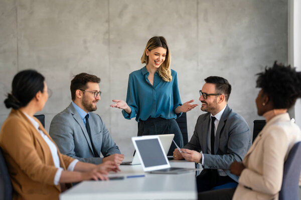 Diverse business people gathered in the office having fun during brainstorming while discussing new ideas for new project. Multiracial coworkers gather in boardroom