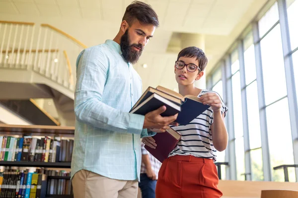 Bir üniversite kütüphanesinde birlikte çalışan mutlu bir öğrenci grubu. Eğitim insanları takım çalışması kavramı.