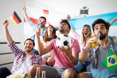 Çok ırklı bir grup insan futbol maçını kutluyor ve eğleniyor.