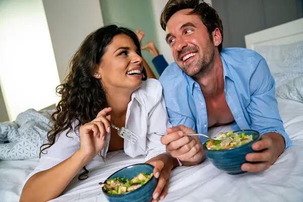 Yatakta Sağlıklı Salata Yiyen Mutlu Genç Çift Aşıklar Hafta Sonunun — Stok fotoğraf