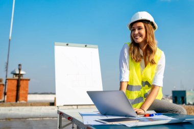 İnşaat alanının planlarını gözden geçiren başarılı genç bir mimar kadın.