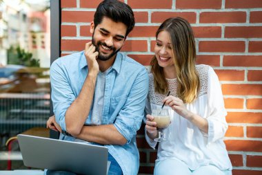 Bilgisayarda ve dijital cihazlarda çalışan mutlu genç çift. İş, eğitim insanları kavramı.