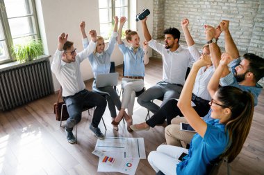 Başarıyı kutlayan ve hep birlikte eğlenen çeşitli iş takımları. Bir grup neşeli coşkulu insan ofiste birbirlerine beşlik çakıyorlar.