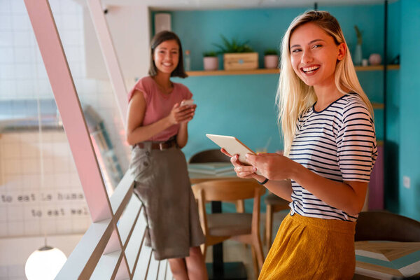 Молодая счастливая женщина работает с планшетом в офисе. Концепция бизнес-образования цифровых устройств