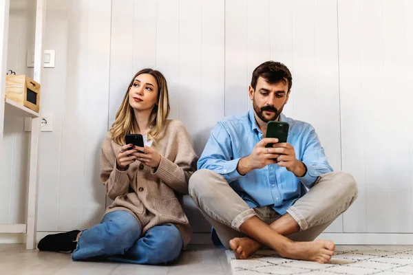 Gadget addiction and relationship problems. Interracial couple with smartphones ignoring each other, playing online games, browsing social media
