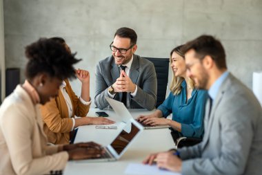 Çeşitli iş adamları ofiste toplanarak beyin fırtınası yaparken yeni proje için yeni fikirleri tartıştılar. Çok ırklı iş arkadaşları toplantı odasında toplandı.