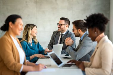 İşletme bürosundaki meslektaşlarıyla birlikte çalışırken analitik rapor sunan başarılı çoklu etnik çeşitlilikte iş adamları