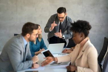 Şirket ofisindeki takım çalışması toplantısında birlikte çalışan çok ırklı başarılı iş adamları grubu..