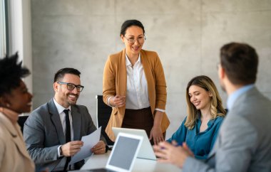 İşletme bürosundaki meslektaşlarıyla birlikte çalışırken analitik rapor sunan başarılı çoklu etnik çeşitlilikte iş adamları