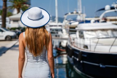 Şapkalı ve güneş gözlüklü güzel bir kadın yaz tatilinde dinleniyor. Seyahat ve yat konsepti.