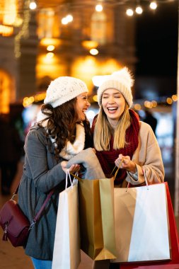 Mutlu kadın arkadaşlar Noel 'de hediye alışverişi yapıyorlar. İnsanlar tatil alışverişi kavramını benimsiyor.