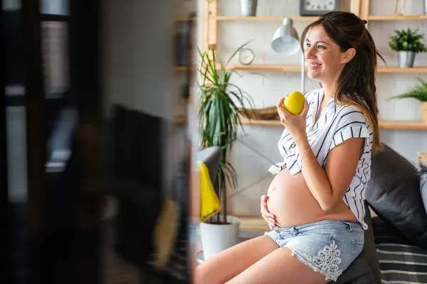 Nutrition and diet during pregnancy. Pregnant young woman pays attention to healthy food and vitamins