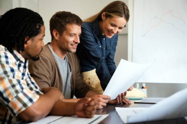 Ofisteki beyin fırtınası sırasında çok kültürlü insanların ortak çalışma süreci. Proje geliştirme konusunda işbirliği yapan çeşitli gençler.