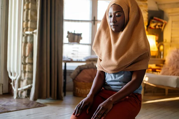 Young muslim black woman praying at home. People religion concept