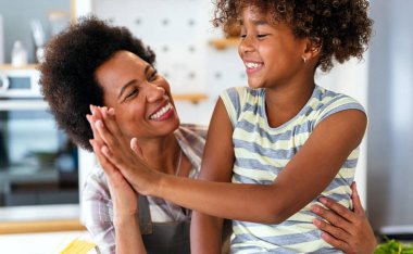 Afrikalı Amerikalı kadın gülümseyen mutlu genç kızına sarılıyor. Aile sevgisi tek ebeveyn çocuk konsepti