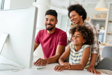 Birlikte tatil yapmayı planlıyoruz. Mutlu Afro-Amerikan babası, annesi ve kızı dijital cihaz kullanıyor, Mutluluk teknolojisi insanlar konsepti.