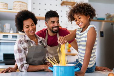 Mutlu Afro-Amerikan ebeveynler ve çocuklar mutfakta sağlıklı yiyecekler hazırlarken eğleniyorlar. Aile mutluluğu eğlence konsepti