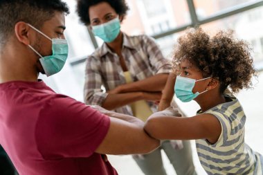 Ev karantinası sırasında maskeli genç Afro-Amerikan ailesi. Ailesi koronavirüs ve grip salgını sırasında maske takıyor. Virüs ve hastalık koruması, COVID