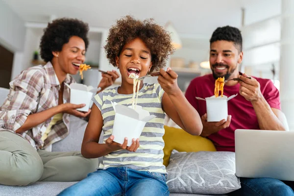 Family home delivary takeaway food concept. Happy african american family eating at living room and enjoying time together.